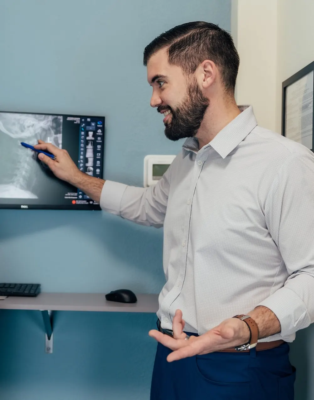 Dr. Brent Johnson pointing to a spine X-ray on a monitor