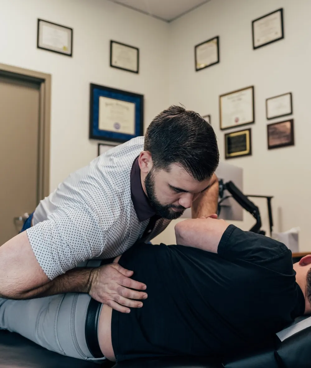 Dr. Brent Johnson adjusting a patient's lower back on a chiropractic table