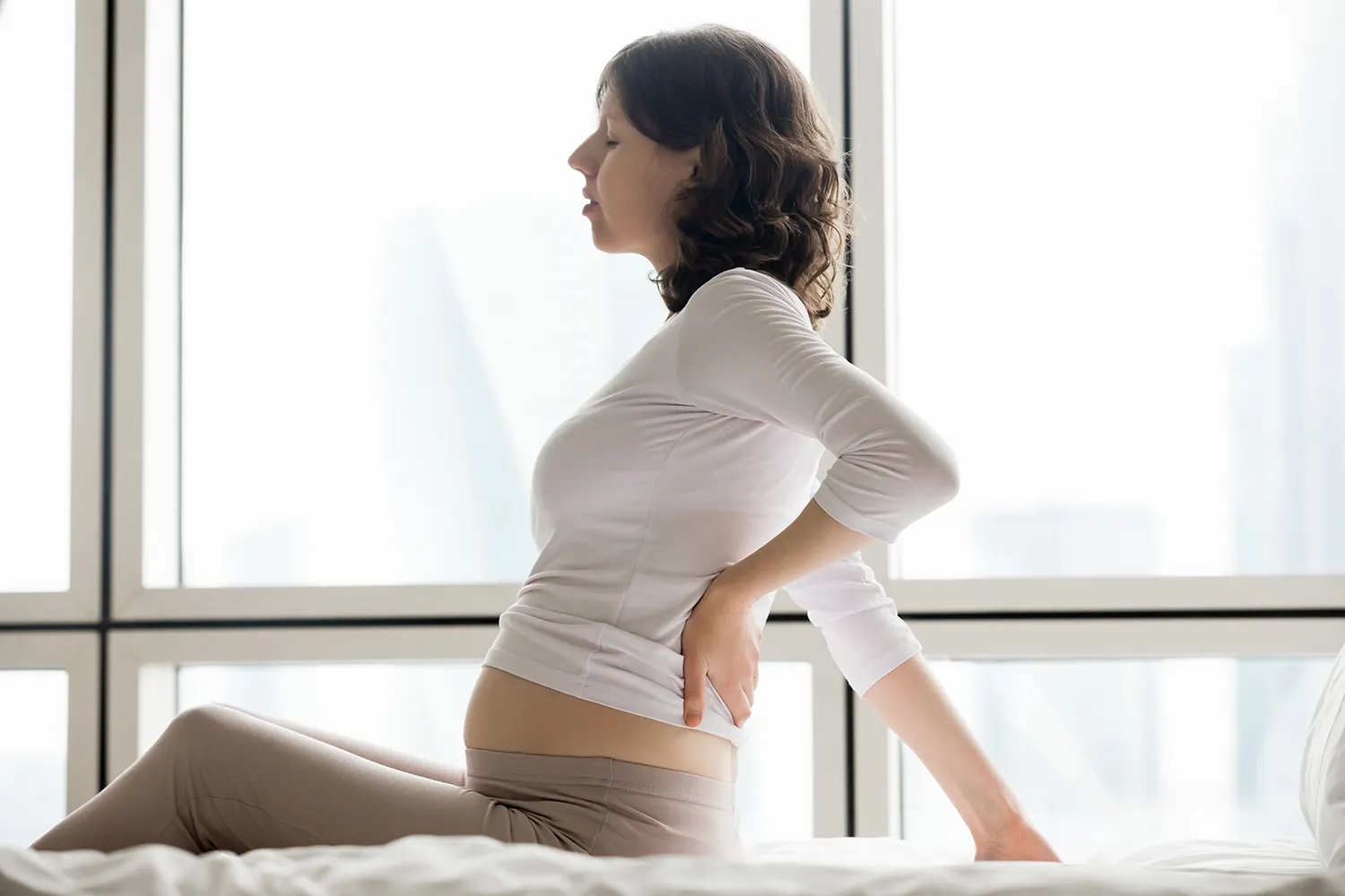 a woman having a back pain while in her pregnancy