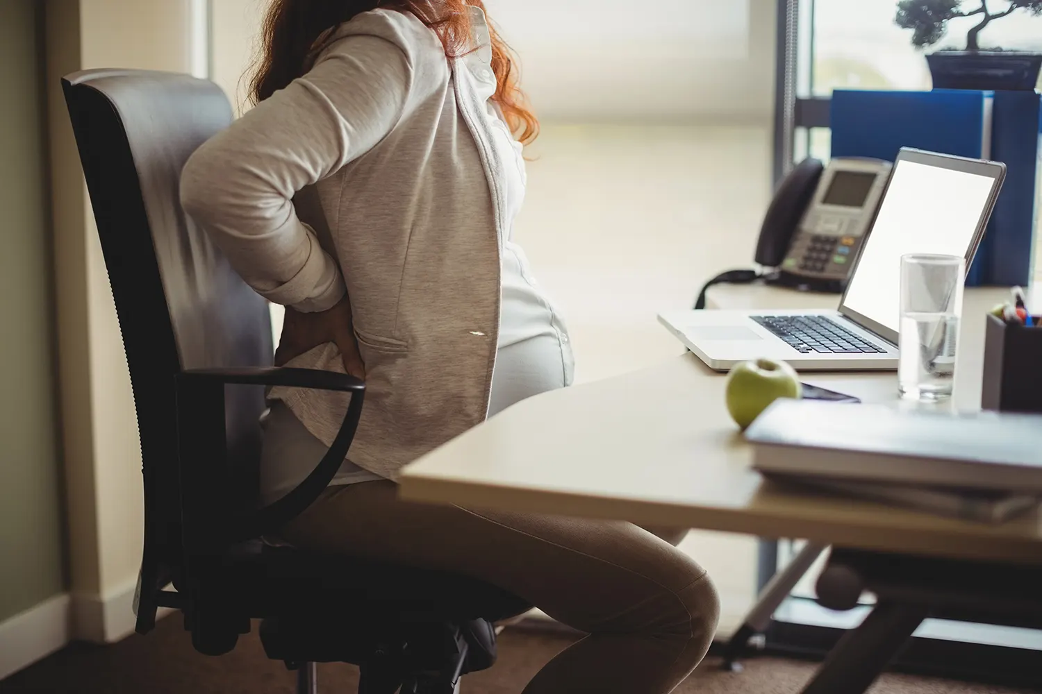 a woman touch her back pain from pregnancy