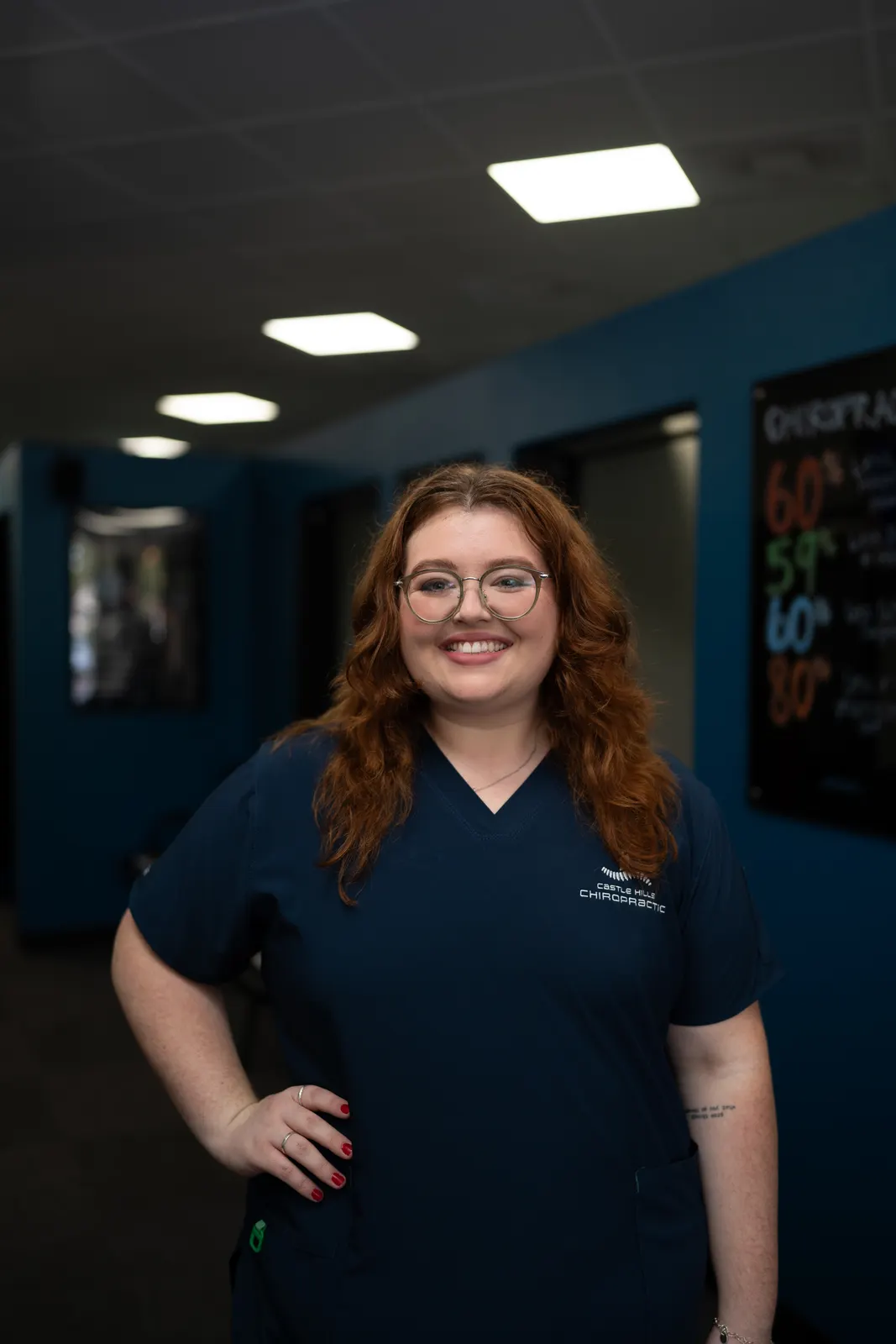 Claire Hall, Chiropractic Assistant at Castle Hills Chiropractic, in navy scrubs