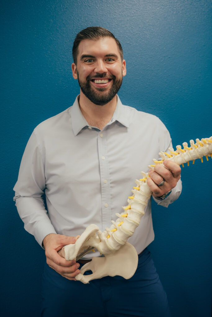 Dr. Brent Johnson holding a full spine model